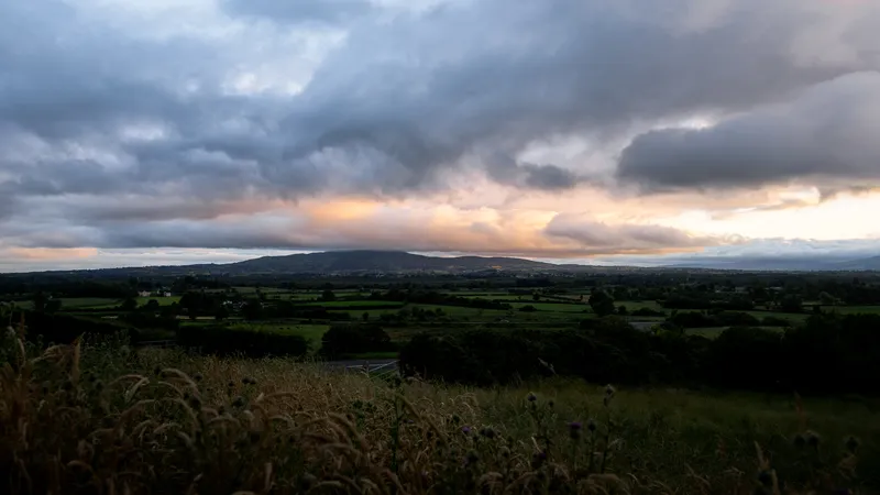 Patchwork countryside at dusk under a moody sky