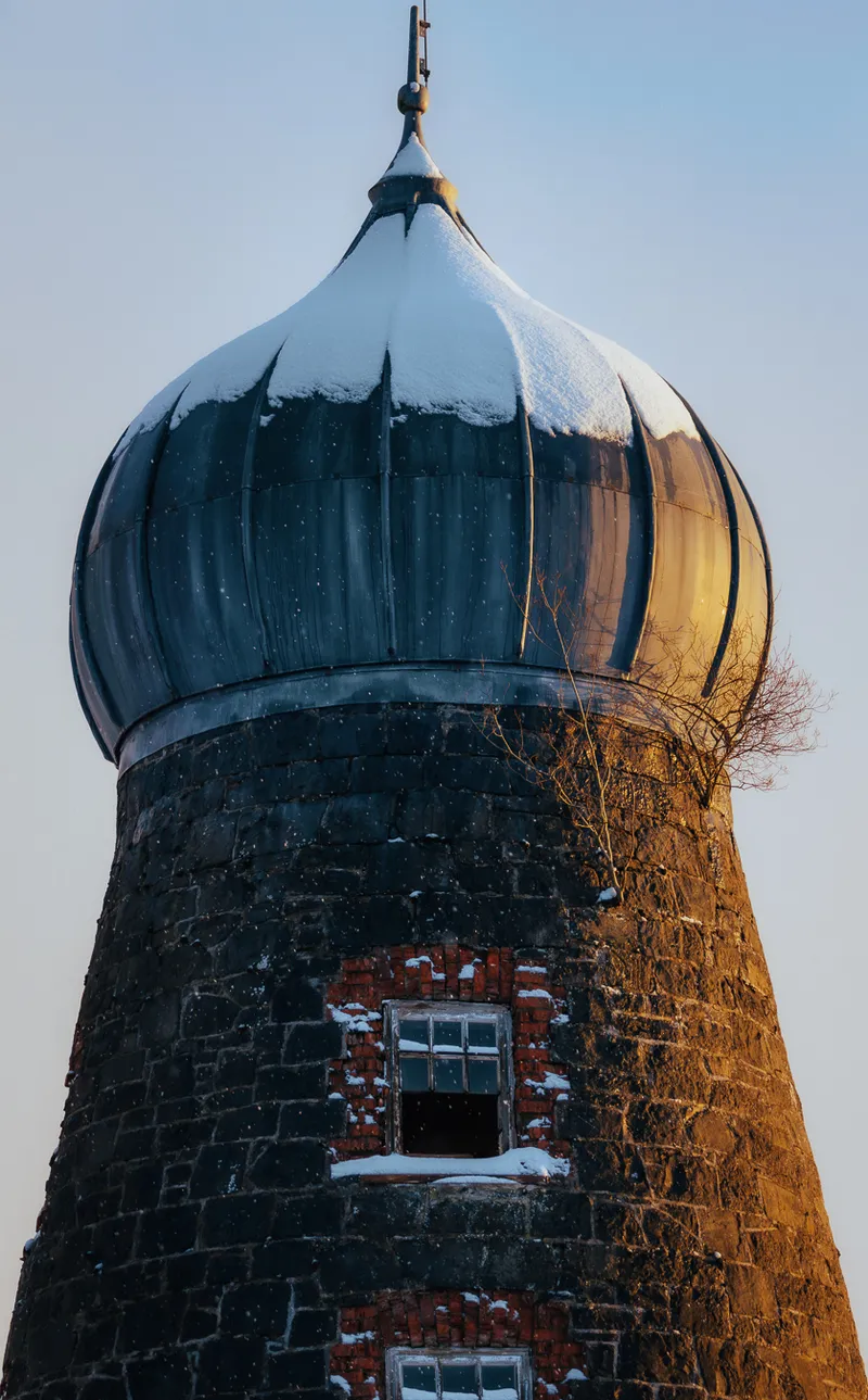 Snow-capped onion-dome tower at golden hour