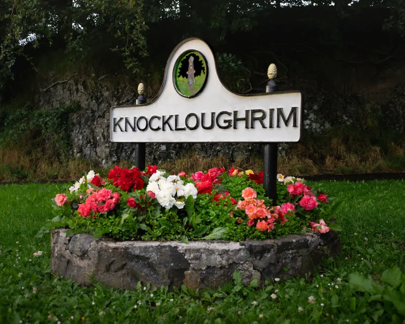 Knockloughrim village sign with a flower bed